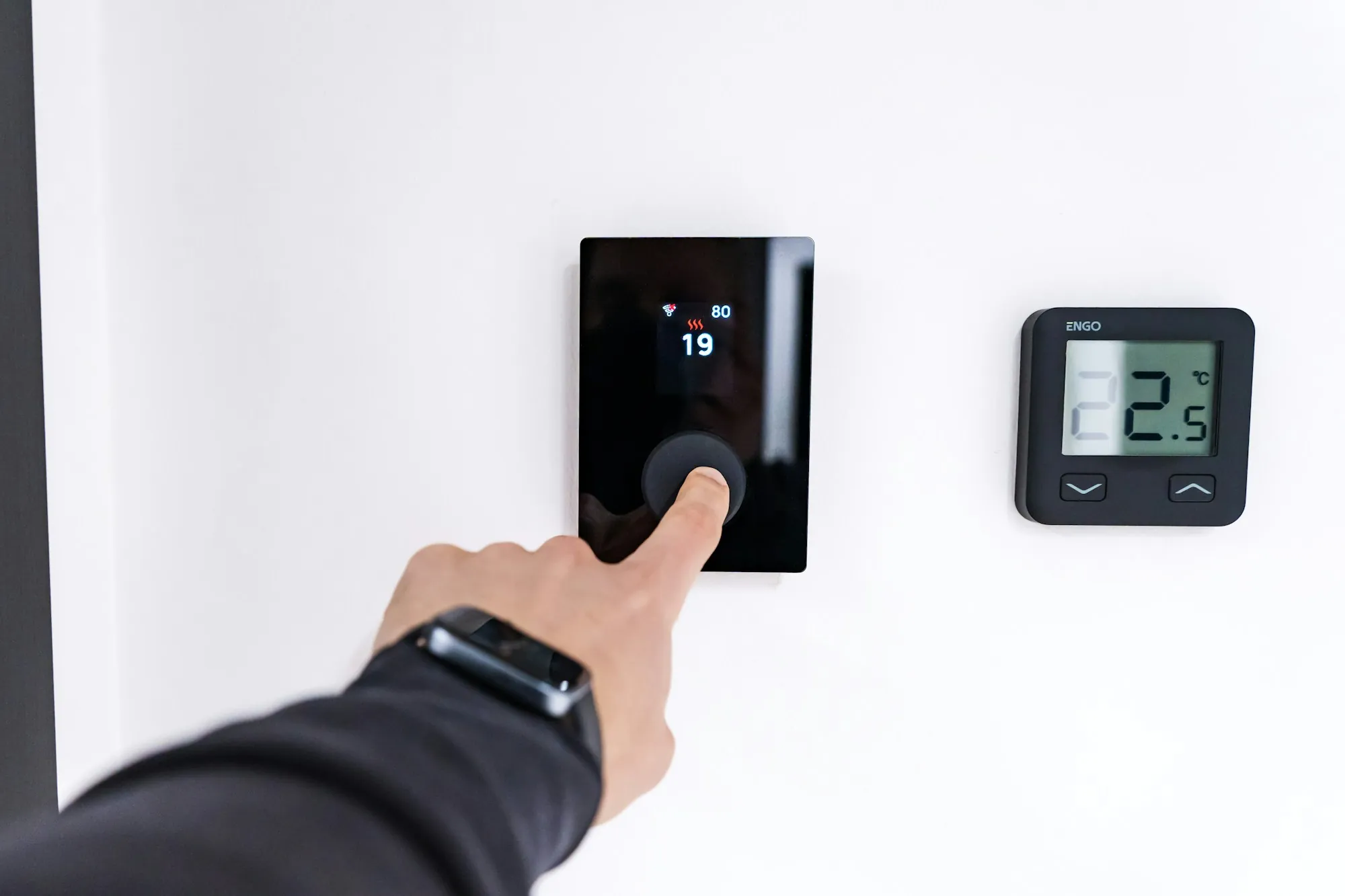 Finger adjusting a digital water heater control