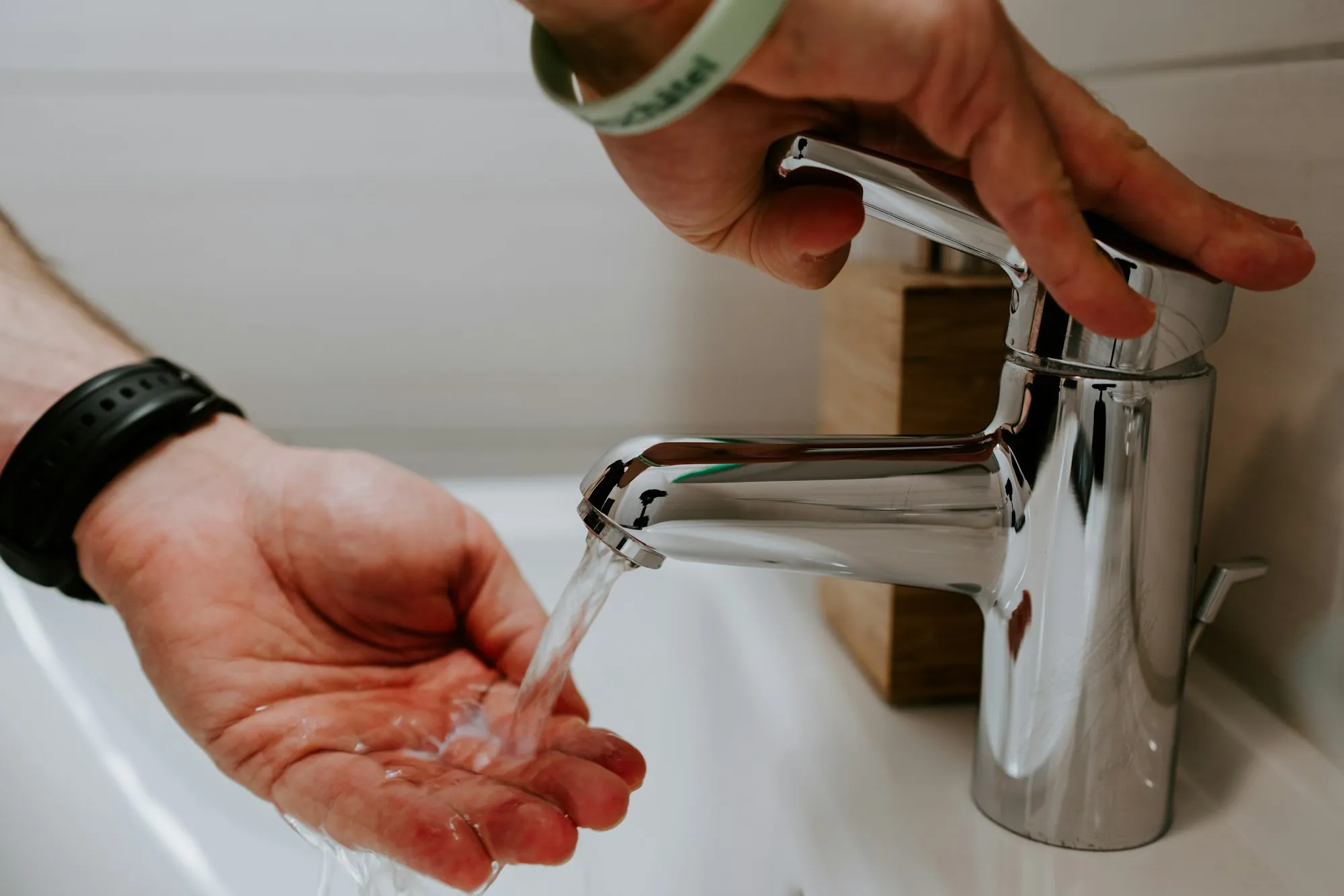 Three Steps to Better Water Hands under a running chrome faucet