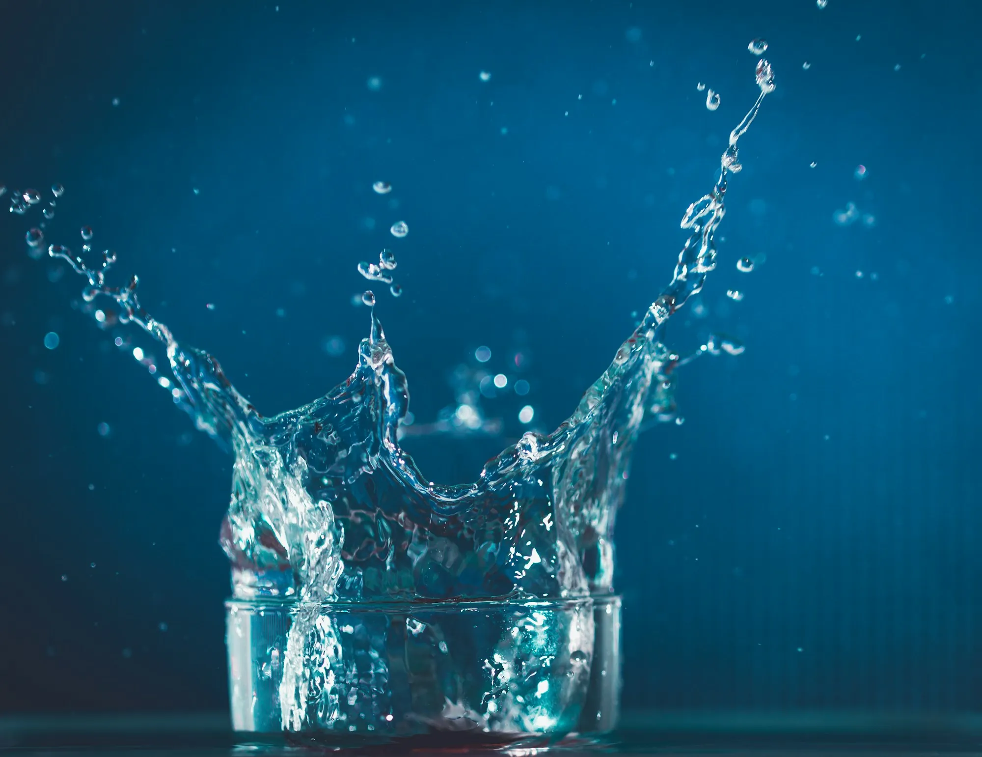 Water splashing into a clear drinking glass